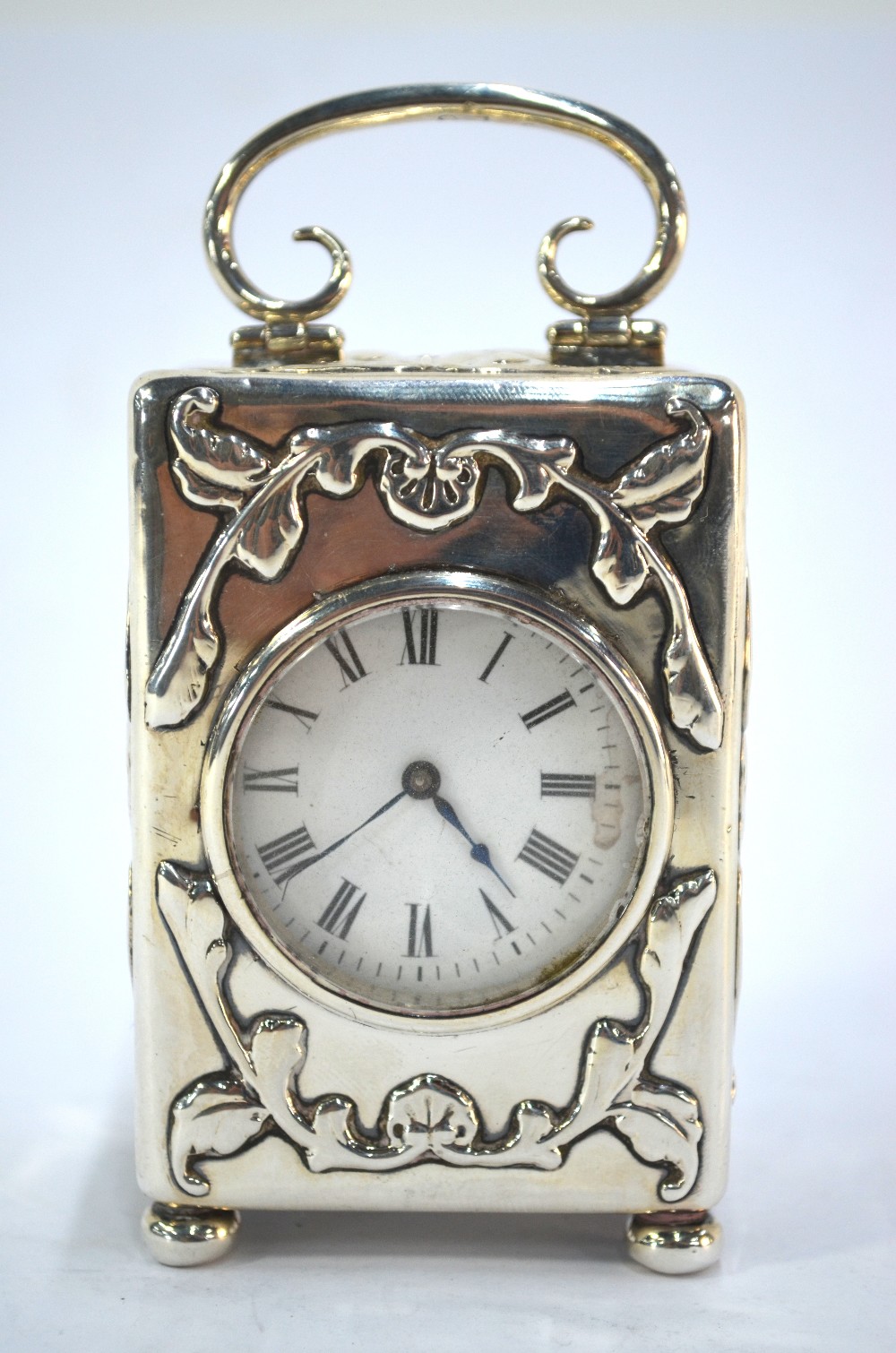 An Edwardian silver boudoir clock, embossed with winged cherub heads and scrolls, swing handle and - Image 2 of 7