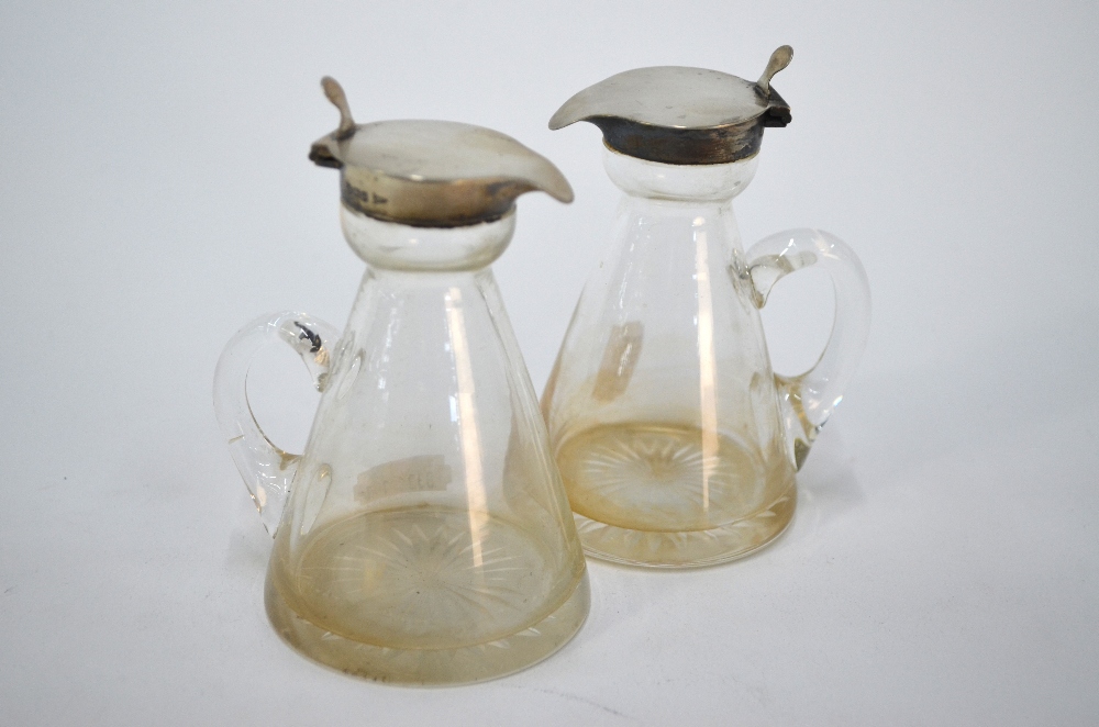 A pair of Edwardian conical glass whisky noggins with star-cut bases and silver collars and
