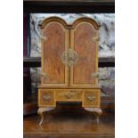 A miniature William & Mary style crossbanded walnut double dome top cabinet, the arched doors