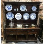 An 18th century or later oak cottage dresser, the plank back rack over a three drawer base and pot