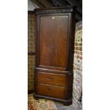 An 18th century mahogany corner cupboard on associated two drawer base, raised on shaped bracket