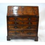 An 18th century walnut bureau, the fall enclosing a fitted interior over four long graduated