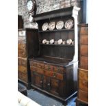 An 18th century country oak cottage dresser, the moulded canopy over a plank backed rack and two