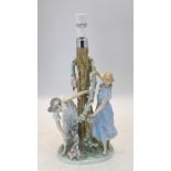 A Lladro lamp base with two maidens decorating a tree with a floral garland, 1607 impressed to base,