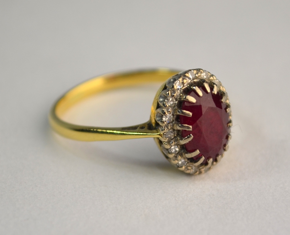 A ruby and diamond oval cluster ring, yellow and white claw setting, size P, not marked