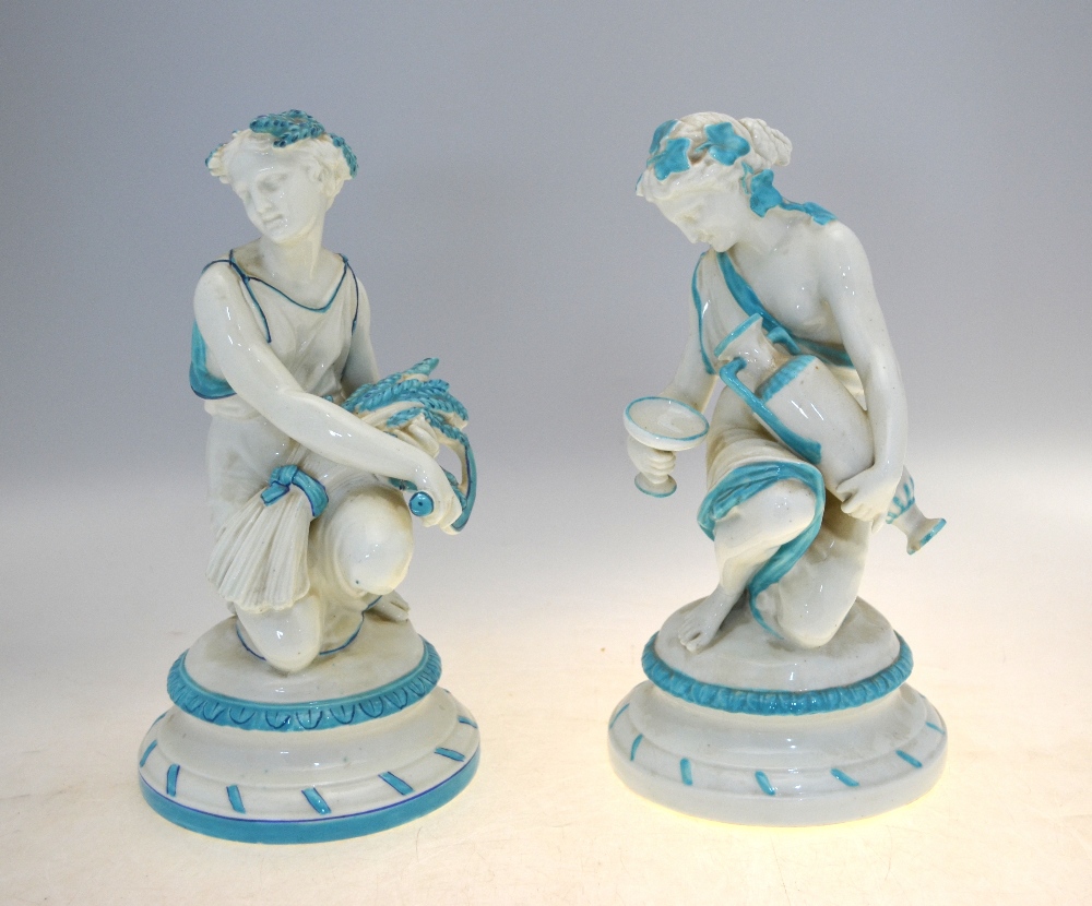 A matched pair of English porcelain classical kneeling figures of maidens, one carrying a sheath