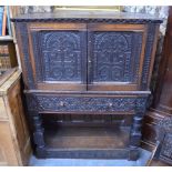 An 18th century and later carved oak jointed cabinet on stand, having well carved cupboard doors