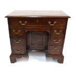 A George III style mahogany knee-hole desk with an arrangement of one long over six short drawers