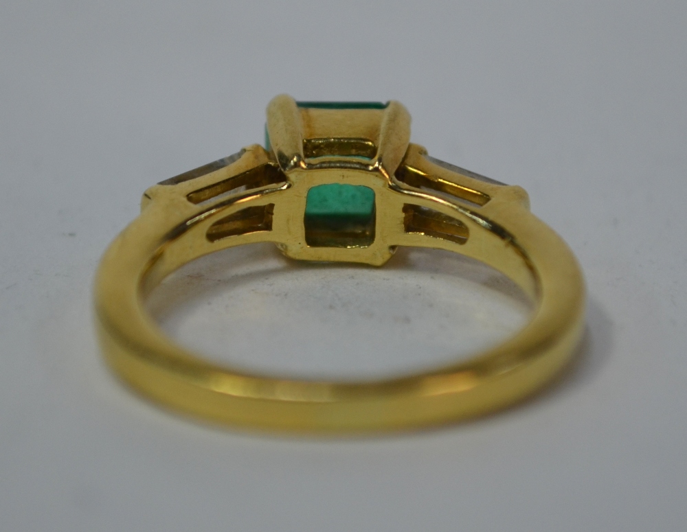 An emerald and diamond three stone ring, the central rectangular emerald having tapered baguette - Image 4 of 6