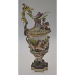 A Naples porcelain wine ewer moulded with putti, dolphins and mermaids, the handle in the form of