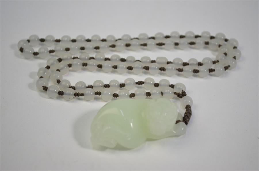 A Chinese jade or glass necklace with about 74 spherical beads and a pendant designed as a recumbent - Image 6 of 10