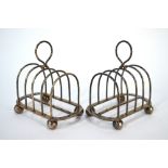 An Edwardian pair of silver four-division toast-racks on ball feet, Fordham & Faulkner, Sheffield