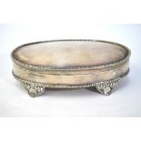 An oval silver trinket box with beaded rims and hinged cover, gilt interior and embossed feet, S