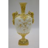 An ornate Victorian Royal Worcester ivory ground urn overlaid in gilt relief with birds in prunus,