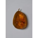 A baroque cut single piece of amber, with yellow metal wire work mount and hanger, 4.6 x 3 cm, 17.9g