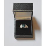 An Art Deco style green tourmaline and diamond cluster ring, the central square cut claw set pale