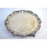 A large silver salver in the Georgian manner, with shell and scroll border, on three claw and ball
