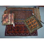 Three old Balouch bag faces to/w a carpet cushion (4)