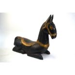 A gilt and painted wood or lacquered figure of a seated mule; possibly Indian, and intended to