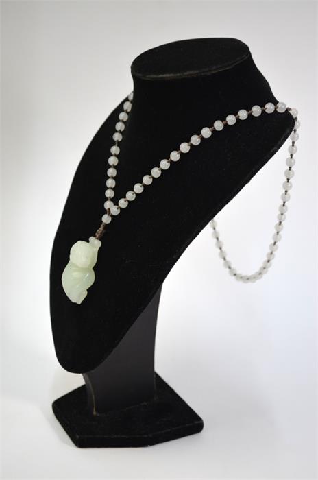 A Chinese jade or glass necklace with about 74 spherical beads and a pendant designed as a recumbent - Image 3 of 10