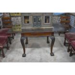 A good quality mahogany drawer leaf dining table raised on hip carved cabriole legs to claw and ball