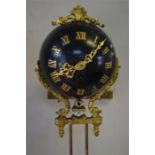 A 19th century gilt and ebonised mystery clock, the movement withing a spherical case with applied