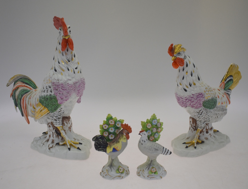 A pair of continental porcelain models of a cockerel, 26.5 cm amd chicken, 21.5 cm, both standing on