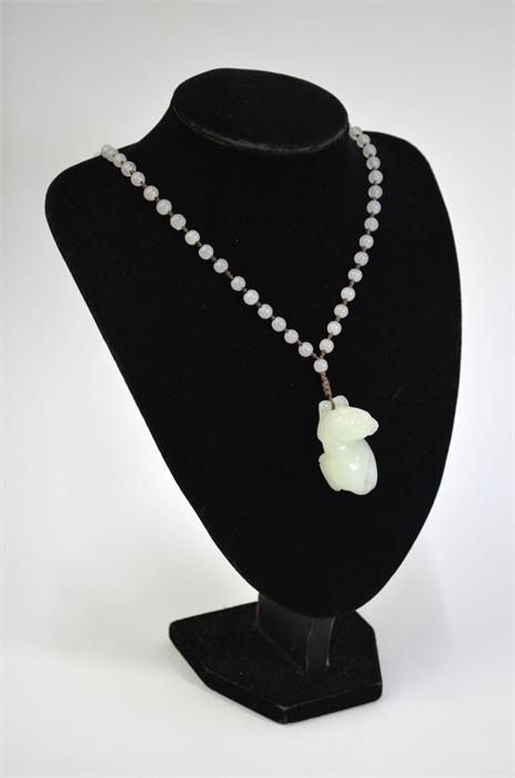 A Chinese jade or glass necklace with about 74 spherical beads and a pendant designed as a recumbent - Image 2 of 10