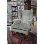 A pair of antique wingback armchairs, upholstered in pale green fabric (2)