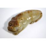 A Chinese mottled green jade figure of a recumbent mythological animal with paws; 7.5 cm long,