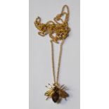 A 9ct yellow gold pendant in the form of a fly, the smokey quartz body flanked by outstretched