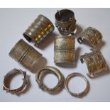 A collection of nine Indian base metal bangles and cuffs, some profusely decorated overall, four