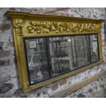 A mid 19th century giltwood framed overmantle, the triple plates beneath a relief carved oakleaf and