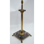 A gilt metal and marble table lamp, the column with acanthus capitol, raised on cast paw feet,