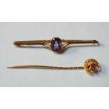 A yellow metal bar brooch set with a central amethyst, stamped 9ct, 5.5 cm long, approx 2.2g all