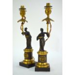 A pair of 19th century French parcel gilt bronze Empire-style candlesticks 'a la Chinoise', modelled