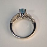 An oval aquamarine ring in contemporary style setting with diamond set shoulders and sides, 18ct