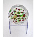A Saint Louis faceted glass paperweight decorated with red cherries on an opaque cane basket weave