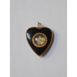 A Victorian black enamel heart-shaped mourning locket, the central circular open locket with seed