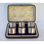 An Edwardian cased set of six silver napkin rings, engraved in the Aesthetic manner and numbered 1-