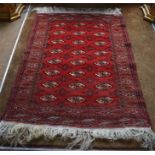 A Turkman Belouch rug, the red ground with three rows of guls, 150 x 110 cm