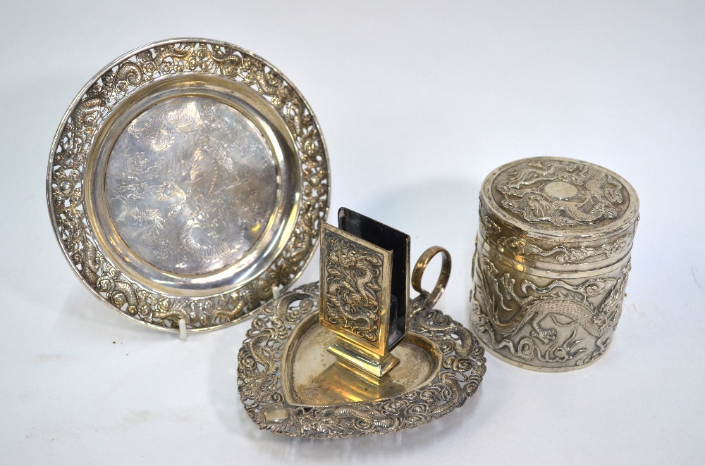 Three pieces of Chinese white metal, comprising: a circular dish, decorated with dragons, 15 cm