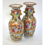 A pair of Canton famille rose vases; each one decorated with panels depicting Manchu/Chinese