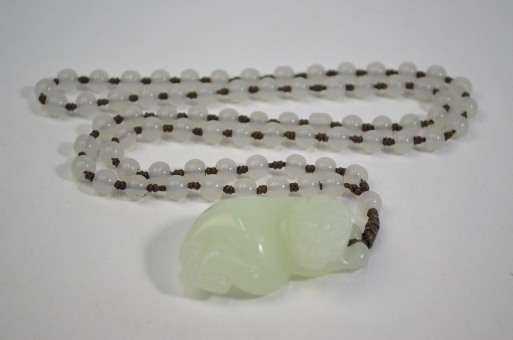 A Chinese jade or glass necklace with about 74 spherical beads and a pendant designed as a recumbent - Image 10 of 10