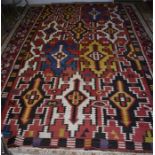 An old Caucasian kelim, the multi-coloured oversize geometric design on red ground, 330 x 180 cm [