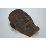 An ethnographic wood mask, possibly from the Batak Peoples of North Sumatra, 31 cm long and 24 cm