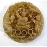A Chinese circular jade applique carved with a reticulated design of three boys; one boy holding a