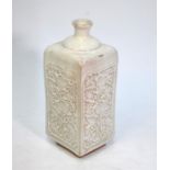 A cream-grey bottle vase of square section; decorated on each rectangular panel with carved floral