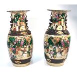 A pair of Chinese famille rose vases, each one decorated with typical scenes of Manchu Bannermen