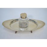 A silver inkstand of elliptical form, on four scroll feet, fitted with a cut glass inkwell with